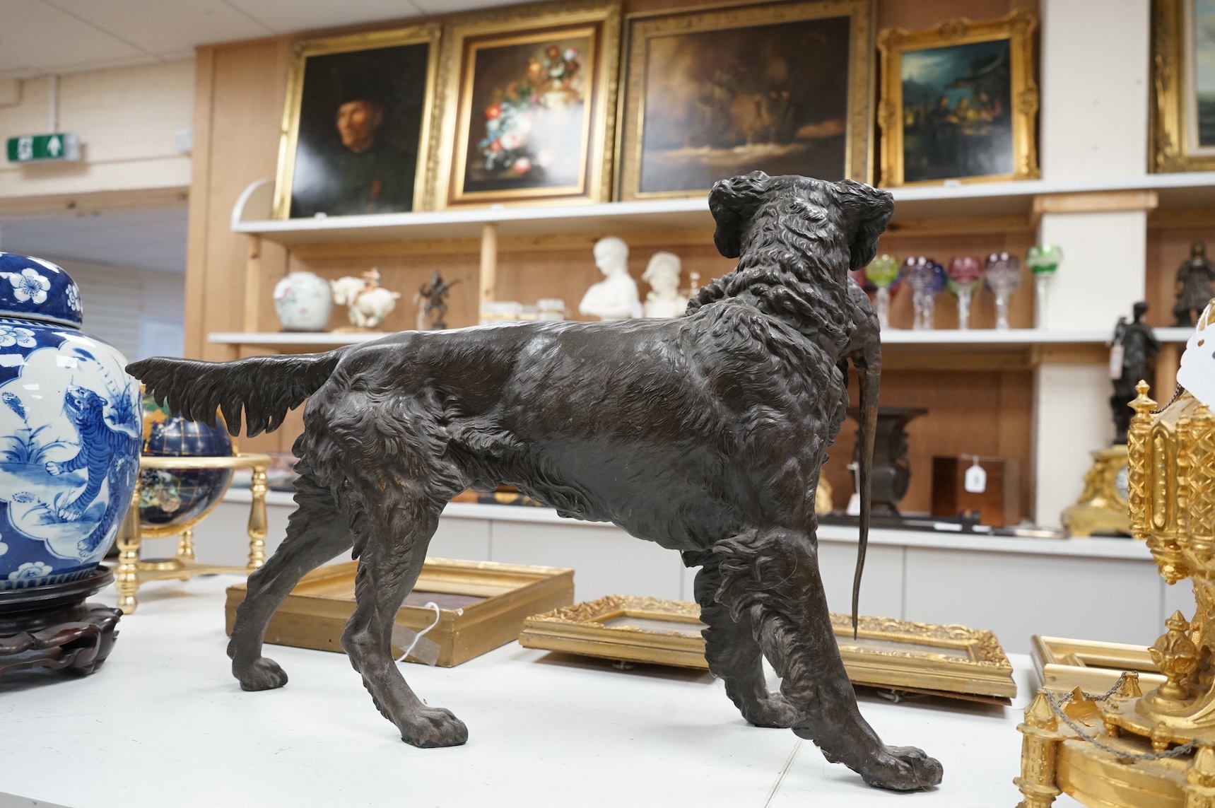 A large bronzed metal study of a retriever and pheasant, 56cm wide
